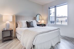 Des Plaines apartment for rent - A bedroom with a large bed and a window overlooking a balcony.