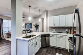Houston apartment for rent - A modern kitchen with white cabinets and stainless steel appliances.