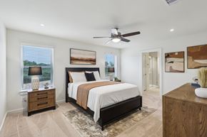 Fulshear apartment for rent - A bedroom with a large bed, a ceiling fan, and a rug on the floor.