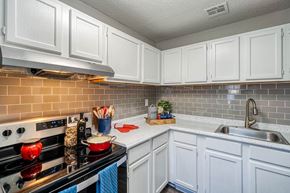 Marietta apartment for rent - a kitchen with white cabinets and a stove and a sink