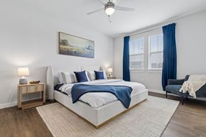 Fort Worth apartment for rent - A bedroom with a large bed and a painting on the wall.