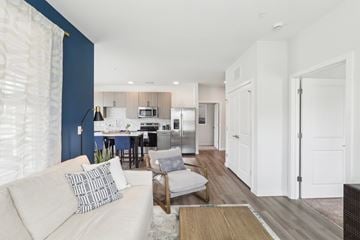 Holly Springs apartment for rent - A modern living room with a white couch and a dining area in the background.
