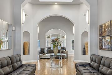 Richardson apartment for rent - A modern living room with a large grey sofa and a glass coffee table.