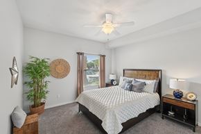 Fort Myers apartment for rent - A bedroom with a large bed and a ceiling fan.