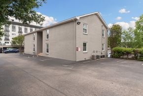 Nashville apartment for rent - A grey building with a parking lot in front.