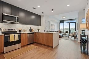 Nashville apartment for rent - A modern kitchen with dark brown cabinets and a wooden island.