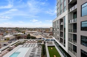 Nashville apartment for rent - A modern building with a pool and a green lawn.