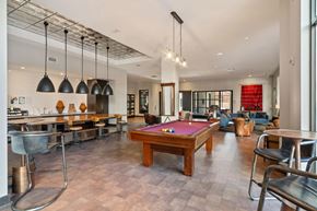 Nashville apartment for rent - A billiard table is in the middle of a room with a kitchen area.