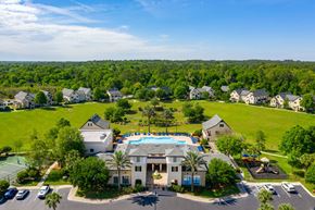 Gainesville apartment for rent - A bird's eye view of a residential area with houses, a swimming pool, and a tennis court.