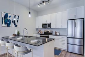 Norwalk apartment for rent - A modern kitchen with a black granite countertop and white cabinets.