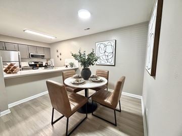 Durham apartment for rent - A dining room with a table set for two and a kitchen area in the background.