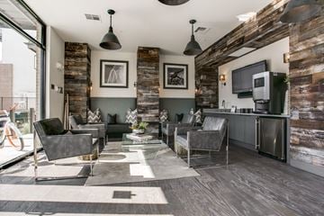 Dallas townhouse for rent - A modern living room with a grey sofa set and a wooden wall.