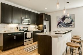 Dallas townhouse for rent - A modern kitchen with black cabinets and stainless steel appliances.