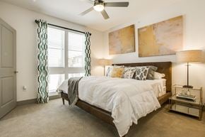 Dallas townhouse for rent - A bedroom with a large bed and a ceiling fan.