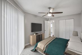Tampa apartment for rent - A bedroom with a bed, a television, and a ceiling fan.