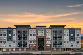 Tacoma apartment for rent - A modern apartment building with a sunset in the background.