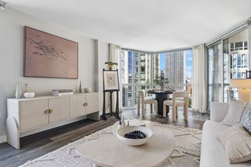 Chicago apartment for rent - A living room with a large painting on the wall and a bowl of blueberries on the coffee table.