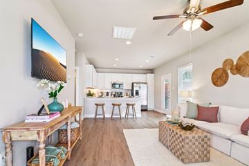 Conroe apartment for rent - A living room with a television on the wall and a white couch.