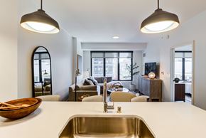 Minneapolis apartment for rent - a kitchen with a white counter top and a living room in the background