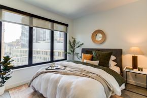 Minneapolis apartment for rent - a bedroom with a large window and a large bed