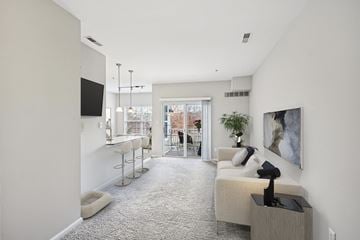 Cherry Hill apartment for rent - A living room with a grey carpet and a white couch.