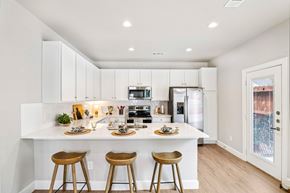 Conroe apartment for rent - A kitchen with white cabinets and a white island with bar stools.