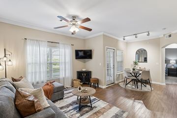 Fort Worth apartment for rent - A living room with a grey couch and a ceiling fan.