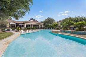 San Antonio apartment for rent - A large swimming pool in front of a house with a sunny sky.