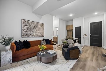 Allen apartment for rent - A living room with a brown couch, a coffee table, and a large abstract painting on the wall.