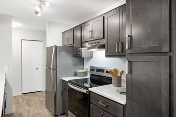Coon Rapids apartment for rent - A modern kitchen with dark wood cabinets and stainless steel appliances.