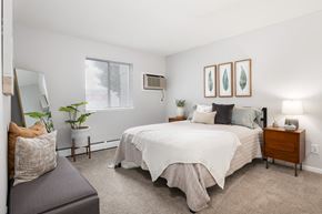 Coon Rapids apartment for rent - A bedroom with a large bed and a grey couch.