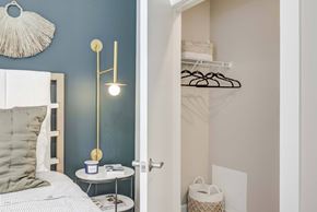 Cambridge apartment for rent - A bedroom with a bed, a nightstand with a lamp, and a closet with clothes.