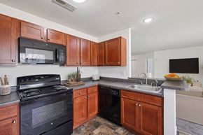 Carlisle apartment for rent - A kitchen with wooden cabinets and a black stove top oven.