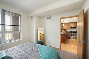 St. Louis Park apartment for rent - a bedroom with a large window and a door to a kitchen at Verge Apartments in St. Louis Park, MN