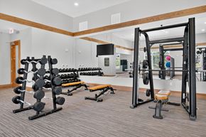 Savannah apartment for rent - A gym with a variety of equipment including a squat rack, bench, and dumbbells.