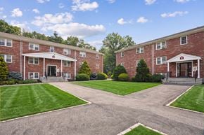 Acton apartment for rent - A large building with a red brick exterior and a white roof.