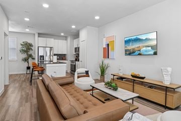 Tomball apartment for rent - A modern living room with a brown leather sofa and a painting on the wall.