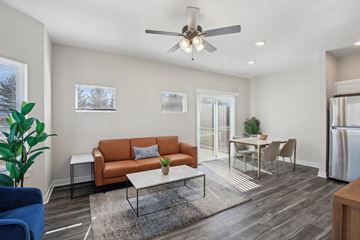 Blue Springs apartment for rent - A living room with a brown couch and a ceiling fan.