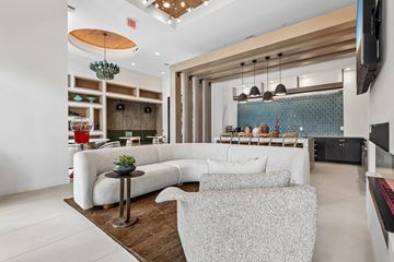 Kissimmee apartment for rent - A modern living room with a white sofa and a wooden coffee table.