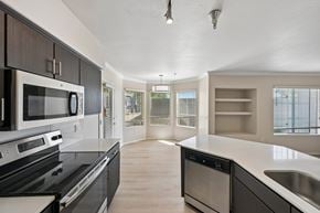 Phoenix apartment for rent - A modern kitchen with a black stove top oven and a microwave above it.