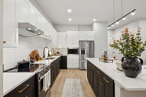 Ft Worth apartment for rent - A modern kitchen with black and white cabinets and a central island.