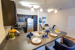 New Bern apartment for rent - A kitchen with a table set for two with blue napkins.