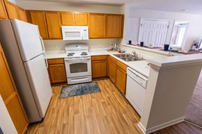 Lynchburg apartment for rent - A kitchen with wooden cabinets and a white refrigerator.