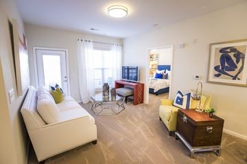 Spartanburg apartment for rent - A living room with a white sofa and a wooden side table.
