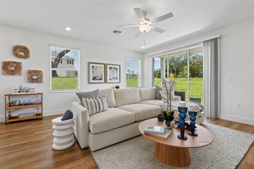 Gainesville apartment for rent - A living room with a white couch, a round coffee table, and a ceiling fan.
