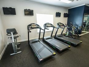 High Point apartment for rent - A gym with treadmills, elliptical machines, and a stationary bike.