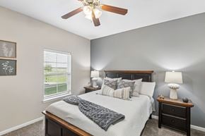 Fort Worth apartment for rent - A bedroom with a bed, nightstand, and a ceiling fan.
