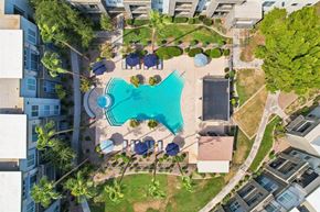 Peoria apartment for rent - An aerial view of a swimming pool surrounded by buildings and trees.