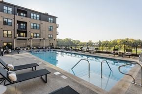 Westfield apartment for rent - A large swimming pool with lounge chairs and a building in the background.
