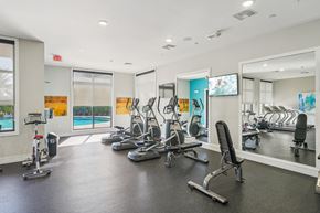 Fort Myers apartment for rent - A gym with a variety of equipment including treadmills, stationary bikes, and weight machines.